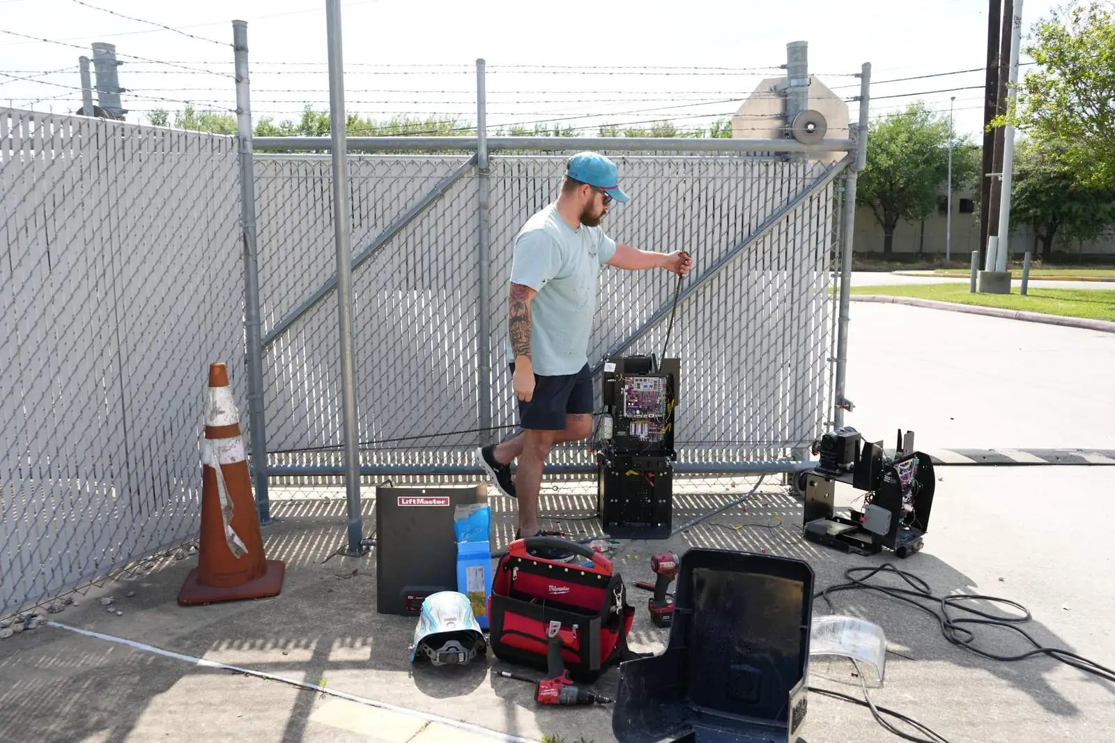 Servicing a slide operator on a commercial chain-link gate.