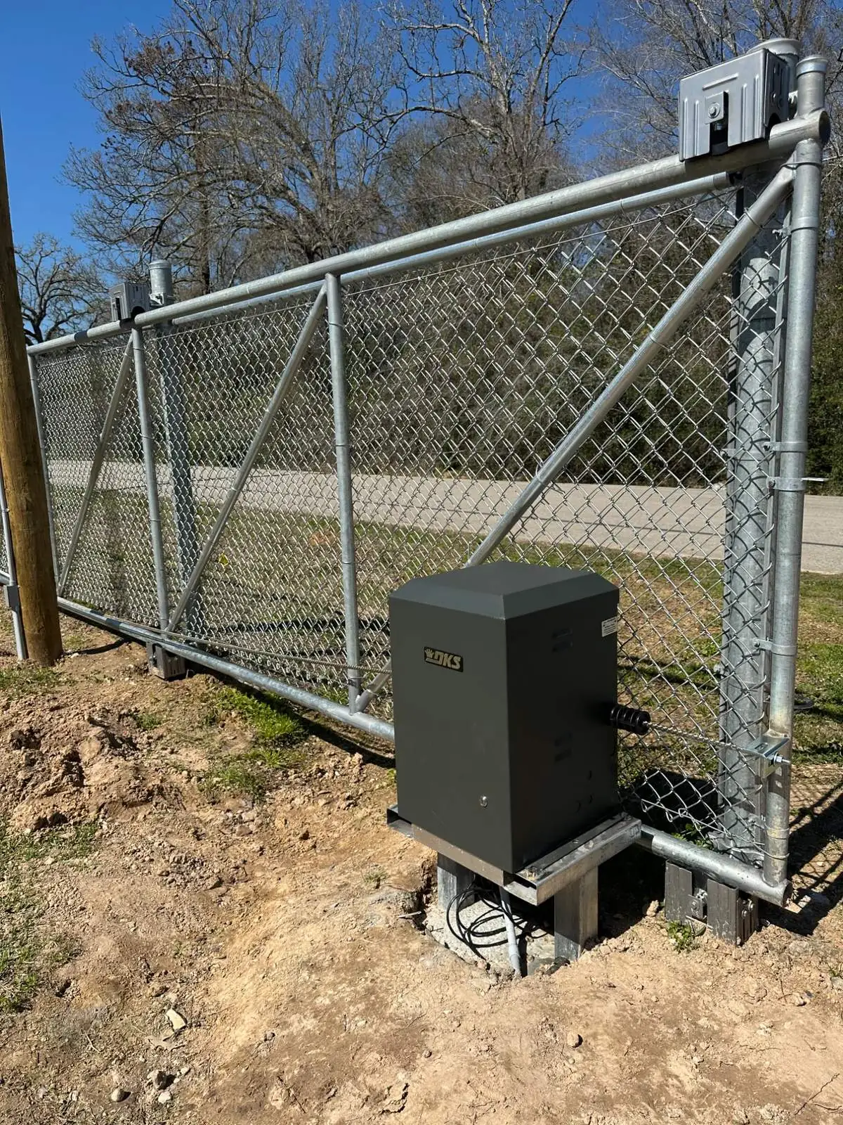 Slide operator mounted on a chain-link gate.