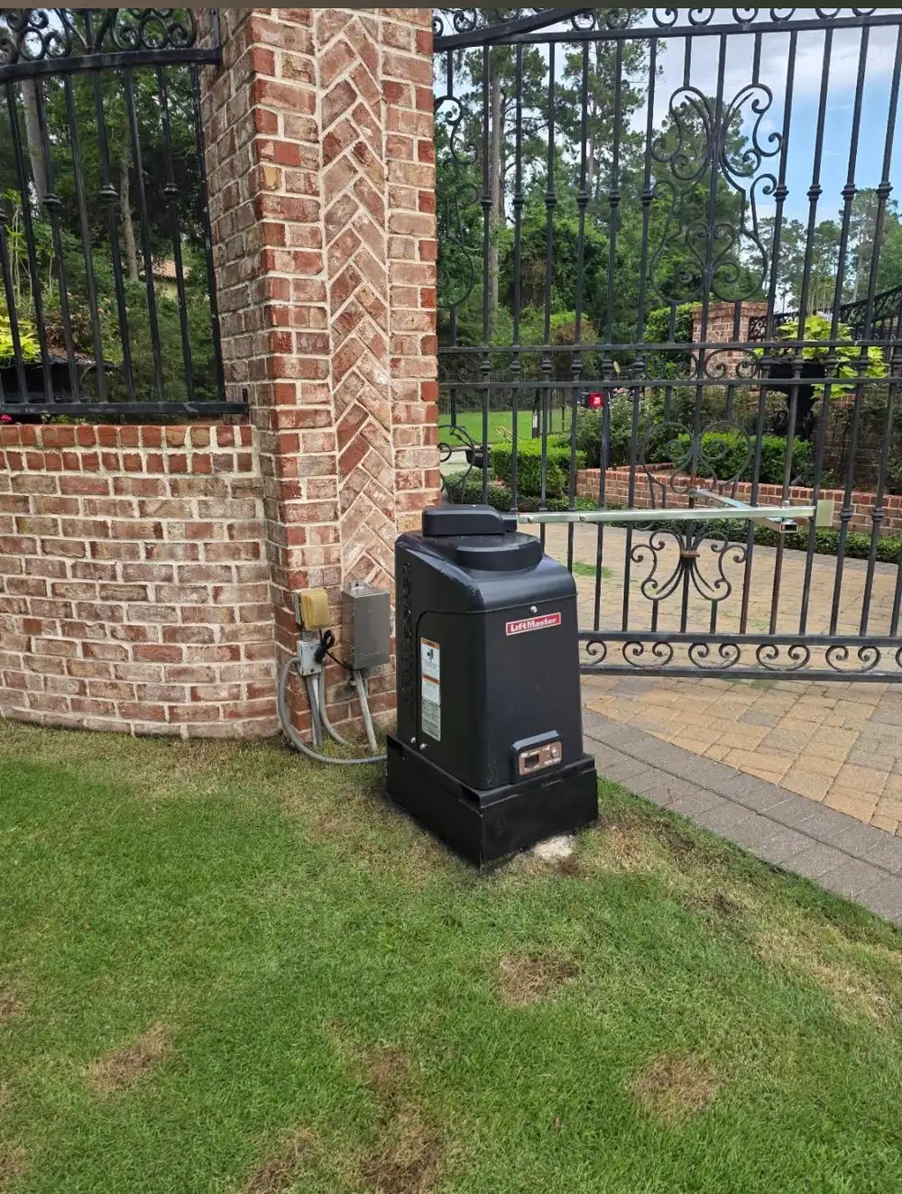 Swing operator mounted beside a brick column.